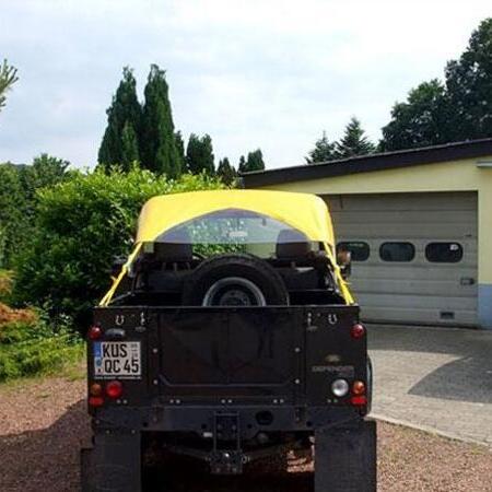 Schwarzer Jeep mit gelben Bikini-Top Cabrioverdeck von hinten