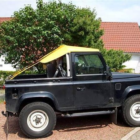 Schwarzer Jeep mit gelben Bikini-Top Cabrioverdeck von der Seite