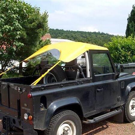 Schwarzer Jeep mit gelben Bikini-Top Cabrioverdeck von der Seite
