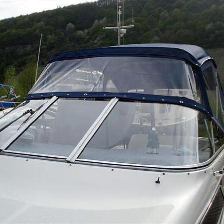 Weißes Boot mit blauem Verdeck am Steg