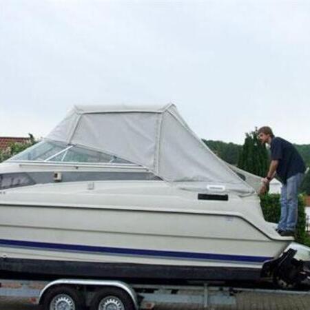 Weißes Boot mit Verdeck auf einem Bootsanhänger