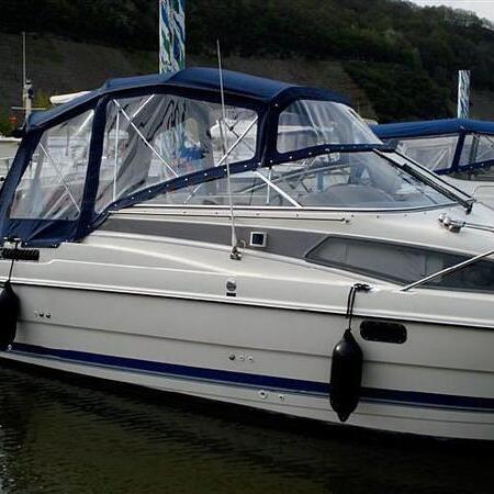 Weißes Boot mit blauem Verdeck am Steg