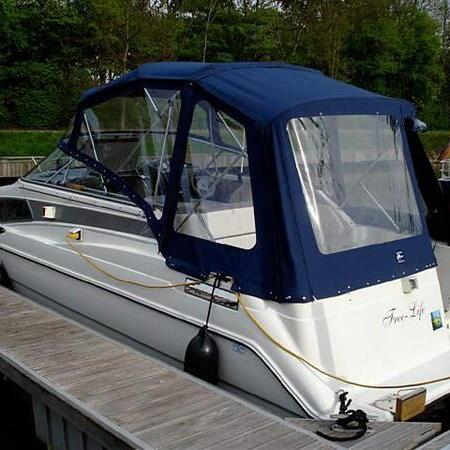 Weißes Boot mit blauem Verdeck am Steg