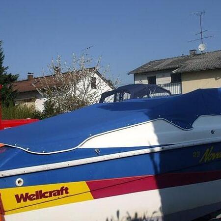 Weißes Boot mit blauem Verdeck am Steg