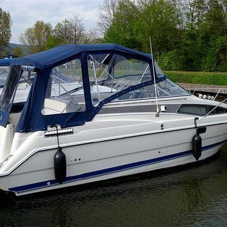 Weißes Boot mit blauem Verdeck am Steg