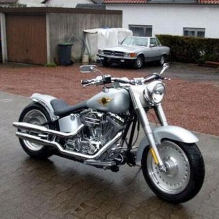 Ein silbernes Motorrad steht auf der Straße