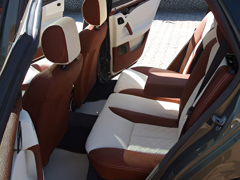 Innenansicht eines Autos mit braunen und weißen Ledersitzen, die eine elegante und moderne Atmosphäre schaffen