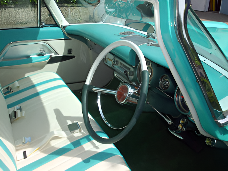 Das Interieur eines Oldtimers zeigt Sitze, ein Lenkrad und das Armaturenbrett