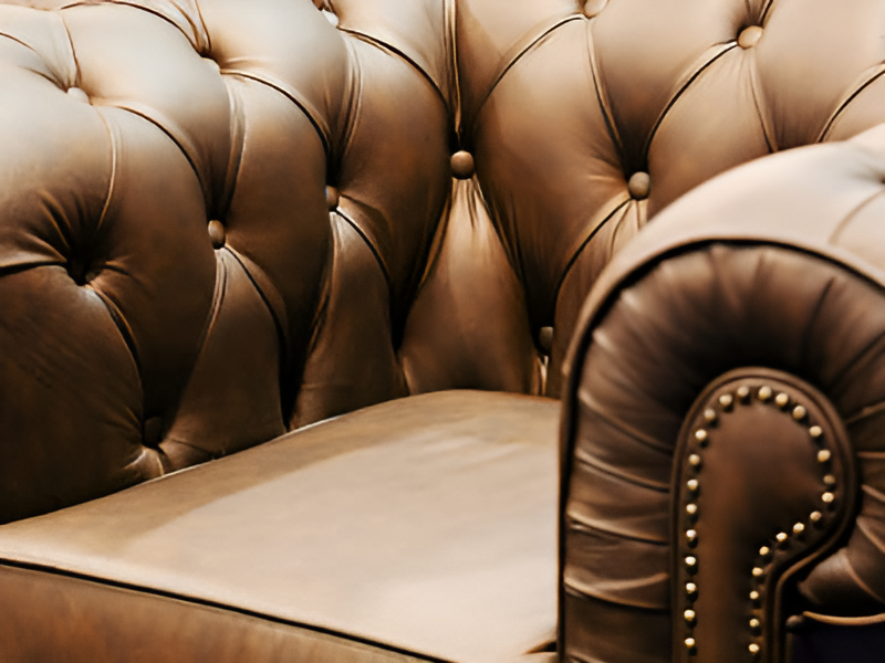Eine braune Ledercouch, elegant und modern, mit weichen Kissen und einem minimalistischen Design